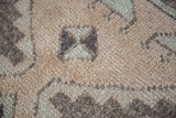 Textured pile of vintage Turkish Oushak rug, featuring beige, grey, and silver motifs.