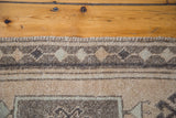 Vintage Oushak rug's top edge, dense fringe, and geometric border in beige and grey.