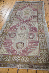 Distressed plum and ivory geometric pattern with bronze tones at the Oushak runner's end.
