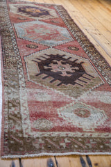 Distressed vintage Oushak runner's geometric motif with worn brick red and silvery platinum tones.