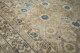 Angled close-up of the vintage Malayer rug showing intricate Herati design in gold, beige, and aqua.