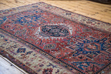 Geometric germinating plants on the unusual beige border of an antique Karaja rug.
