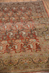 Distressed texture with red rust field and repeating muted paisley boteh.
