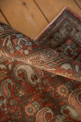 Textured pile of a distressed Persian Birjand rug, revealing red rust and paisley motifs.