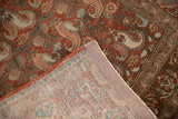 Distressed Persian Birjand rug corner revealing red rust paisley front and knotted foundation.