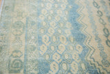 Repeating geometric boteh motifs on vintage Afshar carpet pile in aqua and beige.