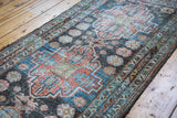 Distressed Malayer runner featuring geometric patterns in soft blue and brick reds.