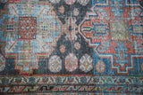 Distressed Malayer runner featuring brick red, soft blue, and denim blue tribal patterns.