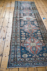 Distressed Malayer runner featuring geometric design in denim blue and brick red.