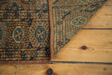 Antique Tekke rug corner reveals intricate geometric patterns and fine weave, brown and teal.