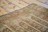 Textured hand-knotted vintage Belouch rug pile showing neutral ivory and golden bronze geometric design.