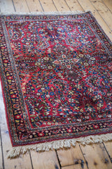 Vintage Sarouk rug detail, showing intricate blossoming flowers on a jewel red field.