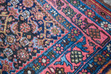 Vintage Persian Bijar rug corner, showing navy Herati motif and coral rose border with green.