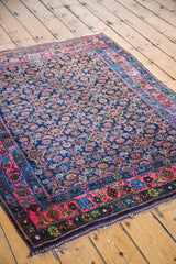 Vintage Bidjar rug's coral rose border and repeating navy Herati motif with unique green details.