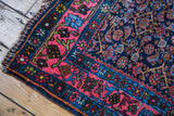 Vintage Bidjar rug corner, coral rose border, navy field, green Herati motifs.
