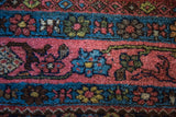 Vintage Bijar rug's vibrant coral rose, bright blue, and unique green Herati pattern bands.