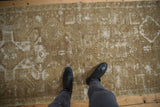 Vintage Oushak runner's distressed character, faded bronze and ivory designs.
