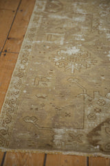 Distressed Oushak runner with faded bronze, ivory patterns and scrolling wave border.