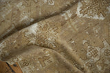 Distressed vintage Oushak rug pile, showing bronze, ivory, and faded alternating designs.