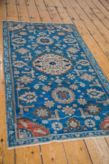 Hand-knotted antique Caucasian rug corner, deep indigo field, stepped red geometric border.