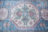 Low bristly pile with brilliant blue geometric design on the distressed Caucasian rug.