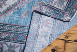 Curled corner reveals distressed low bristly pile and hand-knotted back.