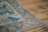 Distressed texture of a Mehraban rug with earthy ivory, golden bronze, and brilliant indigo motifs.