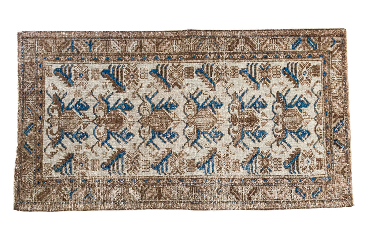 Distressed vintage Persian Mehraban rug with ivory, bronze, and indigo trefoil leaf motif.