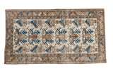 Distressed vintage Persian Mehraban rug with ivory, bronze, and indigo trefoil leaf motif.