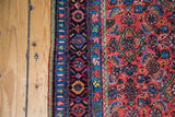 Intricate dark floral border and red Herati pattern with unique green on antique Persian Bidjar.