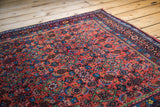 Corner of an antique Bidjar rug, highlighting intricate red Herati motifs with unique green accents.