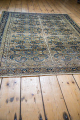Distressed Feraghan rug featuring blue multi-medallion, paisley, and germinating flower motifs.