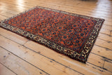 Corner of antique Engelas rug: exquisite Herati design, deep rust field, rich cream border.