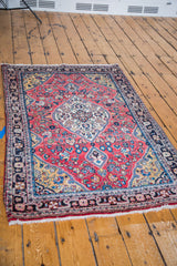 Fine scrolling scalloped medallion and cranberry red abrash field with floral motifs.