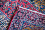 Vintage Josan Sarouk rug's dark border features meandering geometric and pink floral motifs.