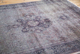 Aged patina on distressed Sivas carpet, revealing faded plum and muted grey floral motifs.