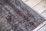 Distressed vintage Sivas carpet pile, revealing muted pattern, worn texture, and soft fringe.