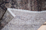 Distressed vintage Sivas carpet fold showing faded pile, white fringe, and hand-woven foundation.