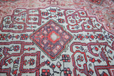 Detailed view of the vintage Malayer rug's central diamond medallion in mauve and red.