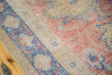 Distressed texture of Oushak rug runner, revealing faded blue and coral patterns.