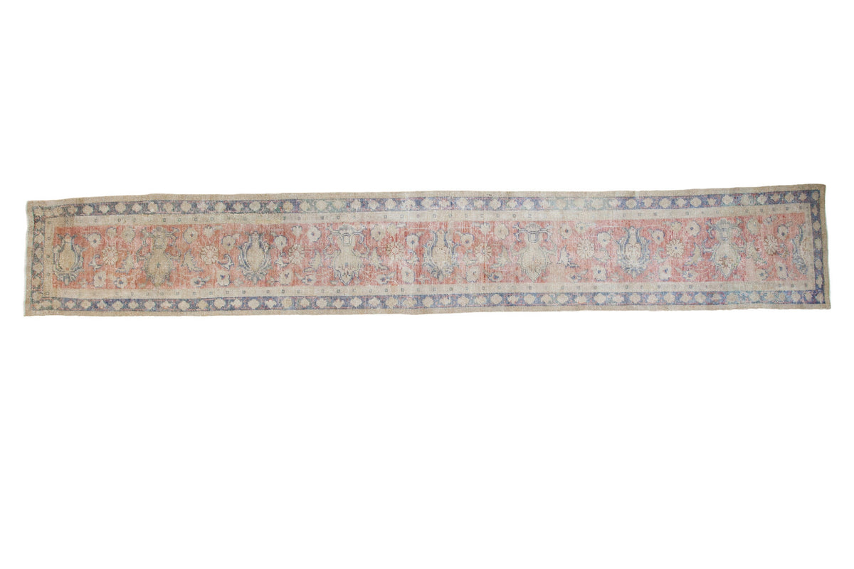 Distressed Oushak rug runner with muted coral, blue lotus flower vines, and geometric borders.