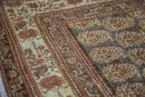 Antique Persian Tabriz rug detail with intricate botanical boteh patterns in rust and earth tones.