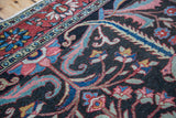Antique Bakhtiari carpet with curvilinear floral motifs in brilliant pink, blue, and red.