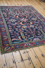 Antique Bakhtiari rug corner featuring dramatic multi-color floral motifs and intricate red border.