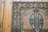 Distressed coral field and blue lozenge medallion corner of a vintage Sivas rug.