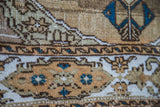 Vintage Sivas rug close-up: soft, distressed texture, geometric bronze and blue designs.