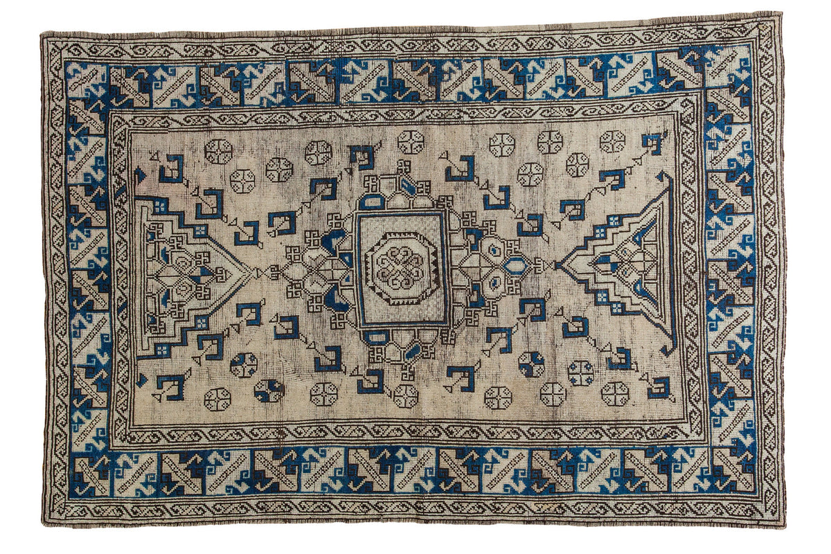 Distressed Oushak rug, beige field, navy and charcoal geometric tribal design, 4'8" x 7'.