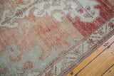 Distressed texture and abrashed cinnabar red and grey tones on a vintage Oushak carpet.