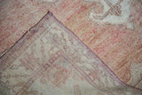 Vintage distressed Oushak carpet pile texture in soft cinnabar, revealing its woven back.