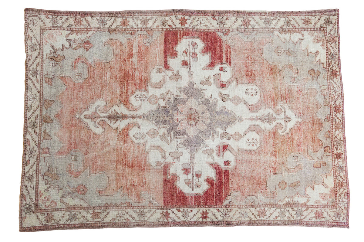Distressed Oushak rug with abrashed cinnabar red field and cream, grey, mauve medallion design.